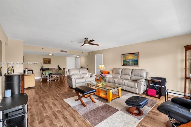 living room featuring hardwood / wood-style floors and ceiling fan