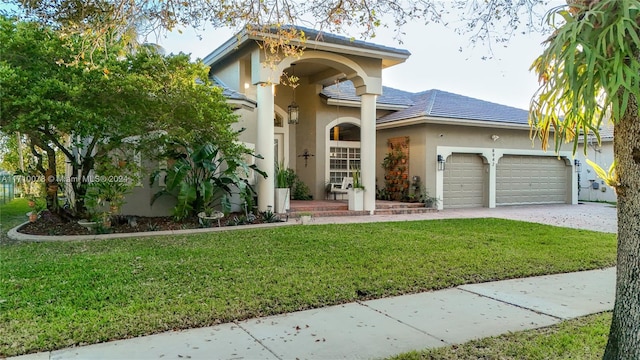 mediterranean / spanish home featuring a garage and a front lawn