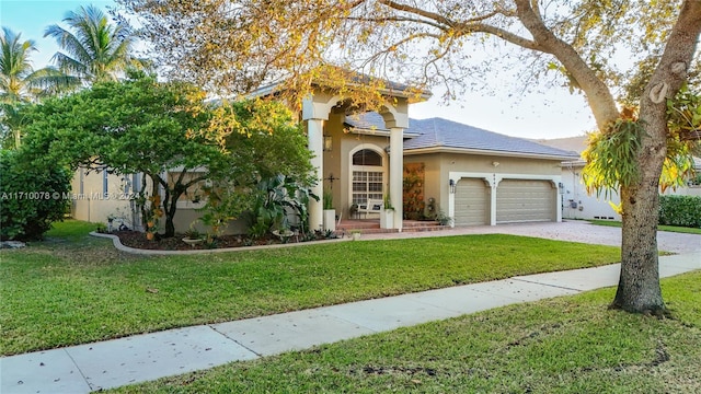 mediterranean / spanish home featuring a garage and a front yard