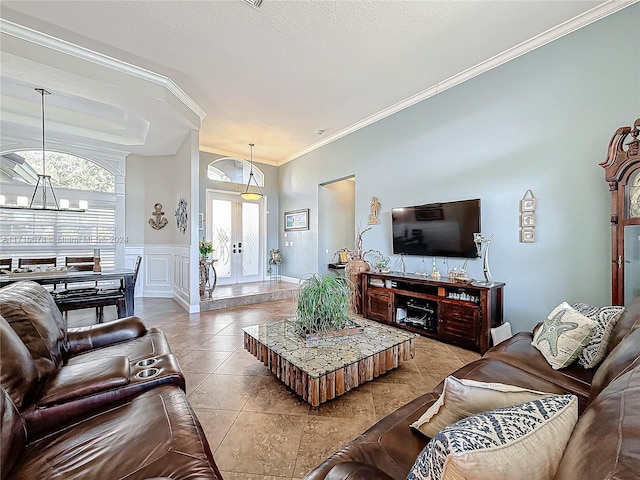 tiled living room featuring crown molding, french doors, a textured ceiling, and a notable chandelier