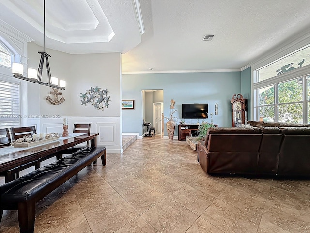 living room featuring ornamental molding, a textured ceiling, and a wealth of natural light