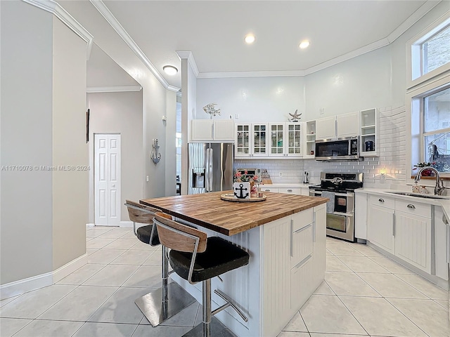 kitchen featuring white cabinetry, a center island, stainless steel appliances, and sink