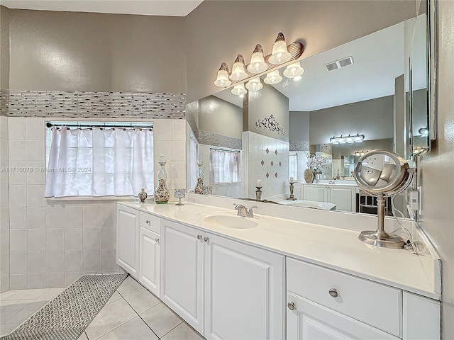 bathroom featuring tile patterned flooring, vanity, tile walls, and tiled shower