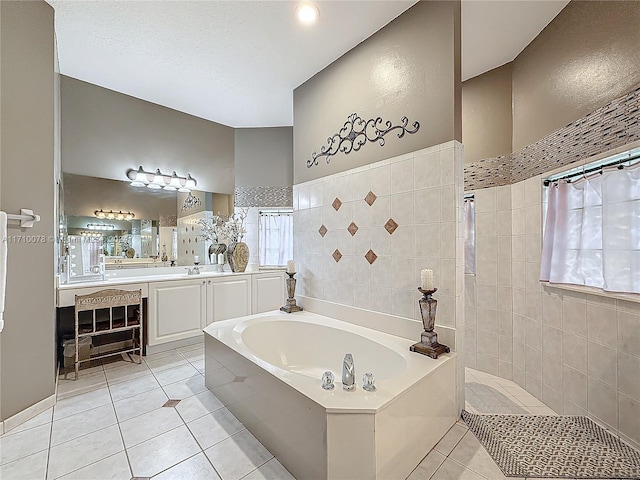 bathroom featuring tile patterned flooring, vanity, a bath, and tile walls