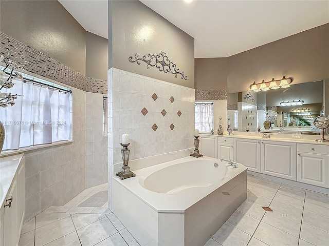 bathroom featuring tile patterned floors, vanity, tile walls, and tiled tub