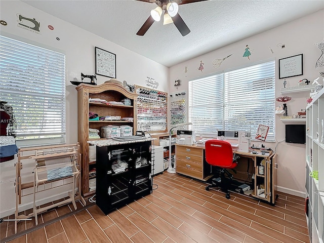 office featuring a textured ceiling, light wood-type flooring, and ceiling fan