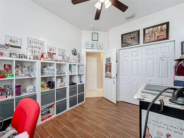 office area with ceiling fan, wood-type flooring, and a textured ceiling