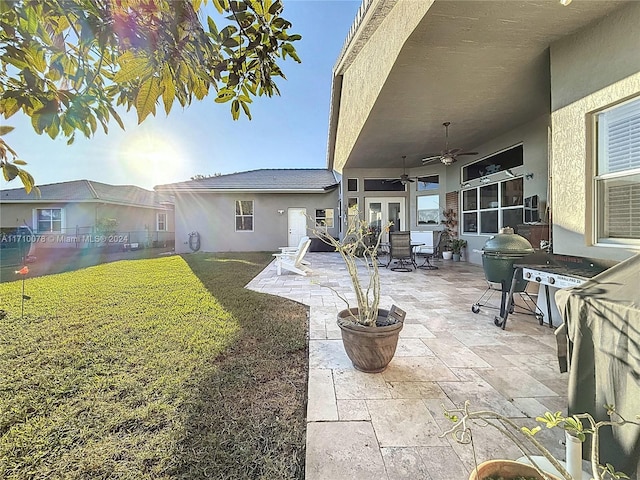 exterior space with french doors, a patio, ceiling fan, and a lawn