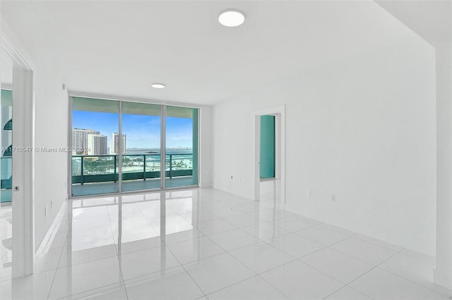 empty room featuring light tile patterned floors and expansive windows