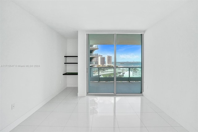 tiled spare room featuring floor to ceiling windows