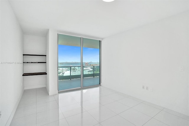 empty room with light tile patterned floors and floor to ceiling windows