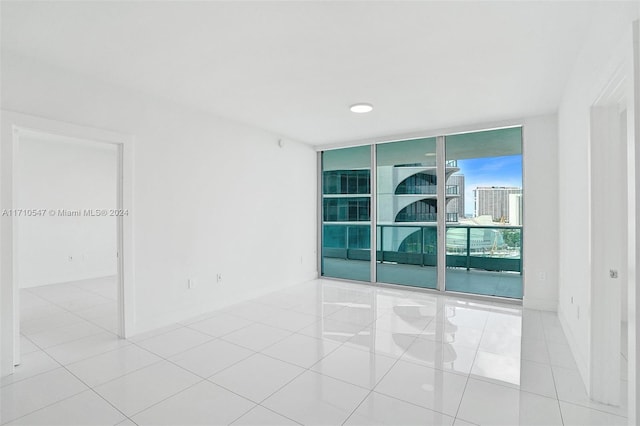 unfurnished room featuring light tile patterned floors and floor to ceiling windows