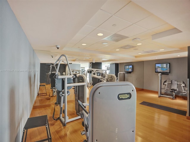 gym featuring light hardwood / wood-style flooring and a paneled ceiling