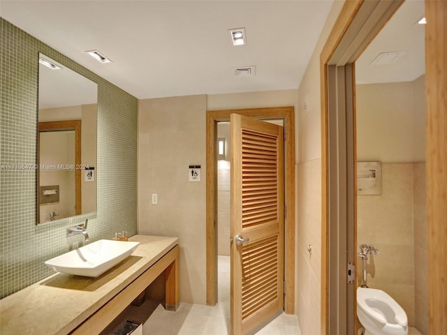 bathroom with tile walls, tile patterned floors, and sink