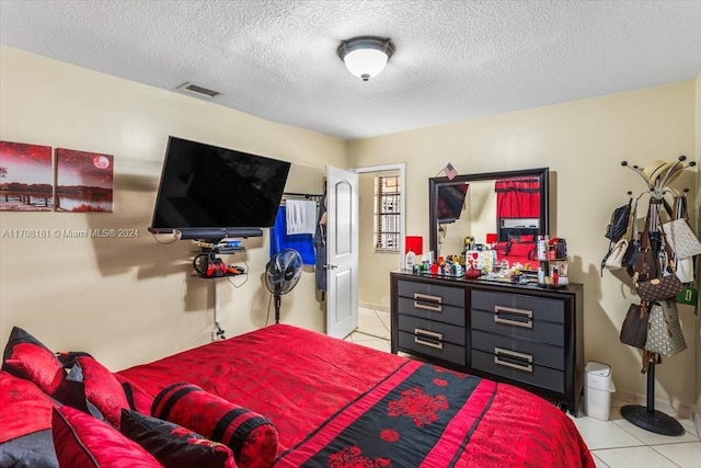 bedroom featuring light tile patterned floors and a textured ceiling