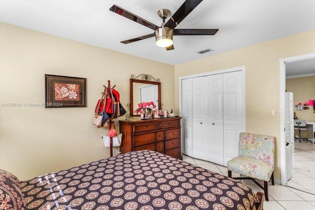 tiled bedroom with ceiling fan and a closet