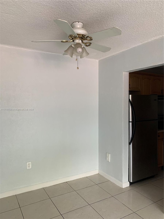 tiled spare room featuring ceiling fan and a textured ceiling