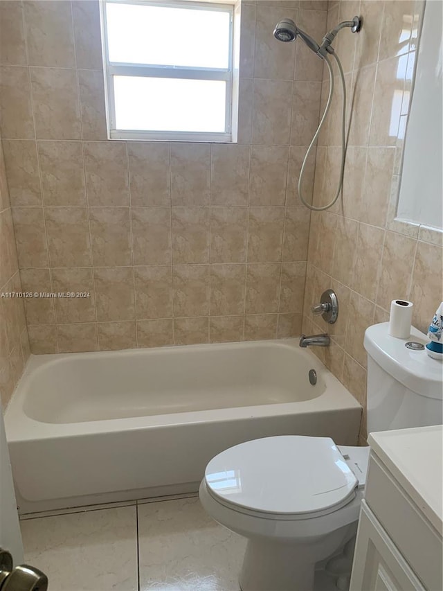 full bathroom with tiled shower / bath combo, tile patterned floors, toilet, vanity, and tile walls