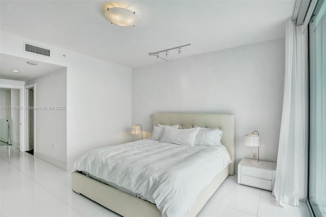 bedroom with rail lighting and light tile patterned flooring