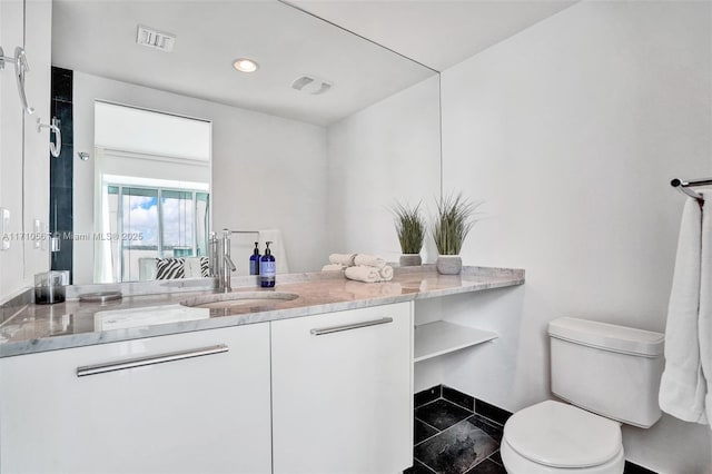 bathroom featuring vanity and toilet