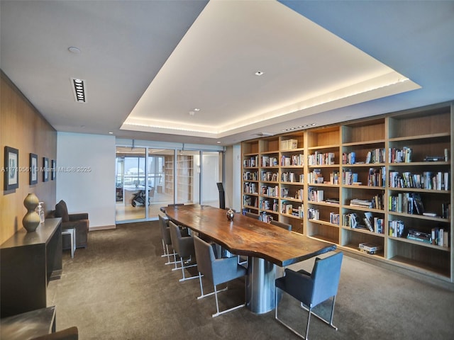 carpeted dining space featuring built in shelves and a tray ceiling