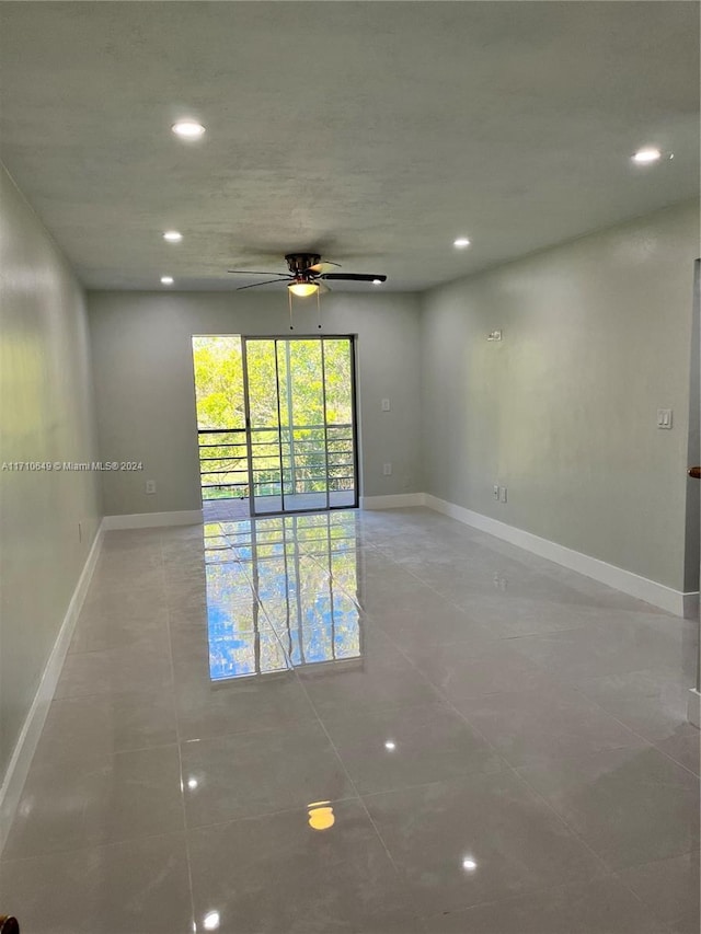 tiled spare room featuring ceiling fan