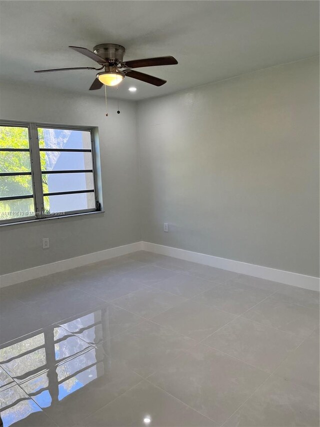 empty room with tile patterned flooring and ceiling fan