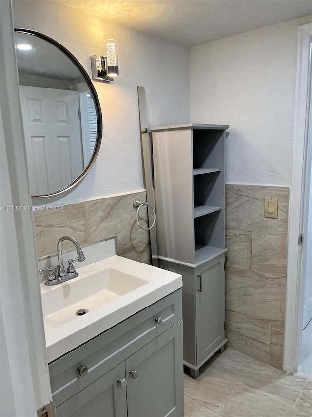 bathroom with vanity and tile walls