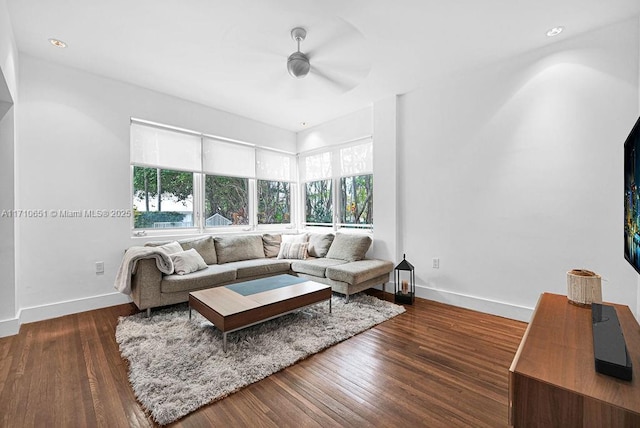 living room with ceiling fan and dark wood-type flooring