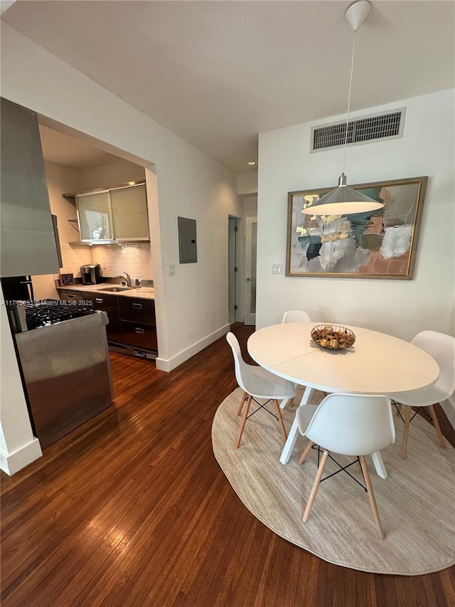 dining room with electric panel, sink, and dark hardwood / wood-style floors