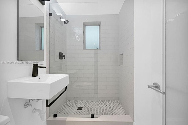 bathroom featuring tiled shower and toilet