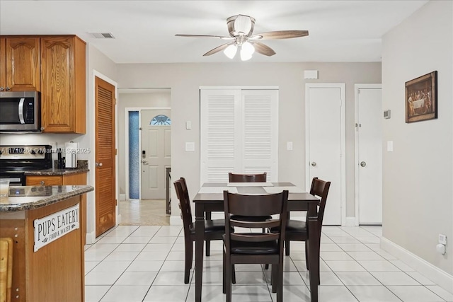 dining space with ceiling fan and light tile patterned floors