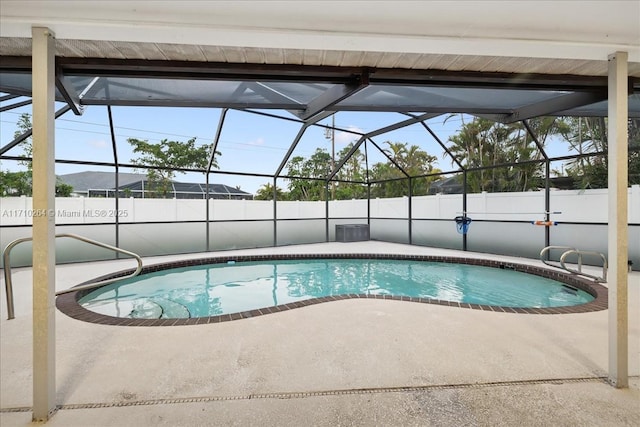 view of pool with a patio and glass enclosure