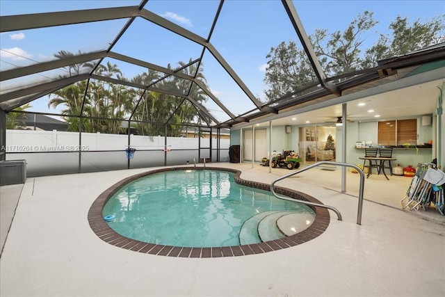 view of swimming pool featuring a lanai and a patio area