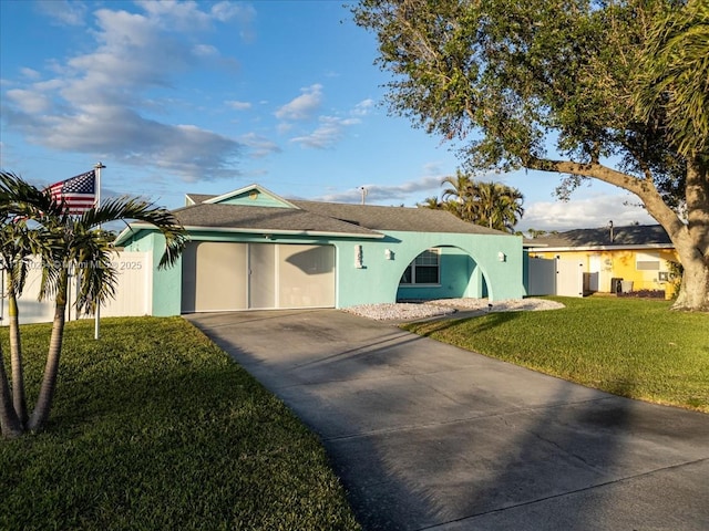 ranch-style home with a garage and a front lawn