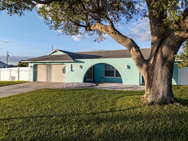 ranch-style home featuring a garage and a front yard