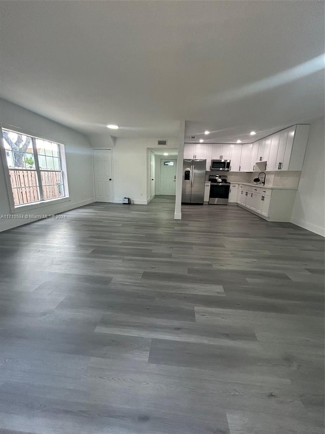 unfurnished living room featuring sink