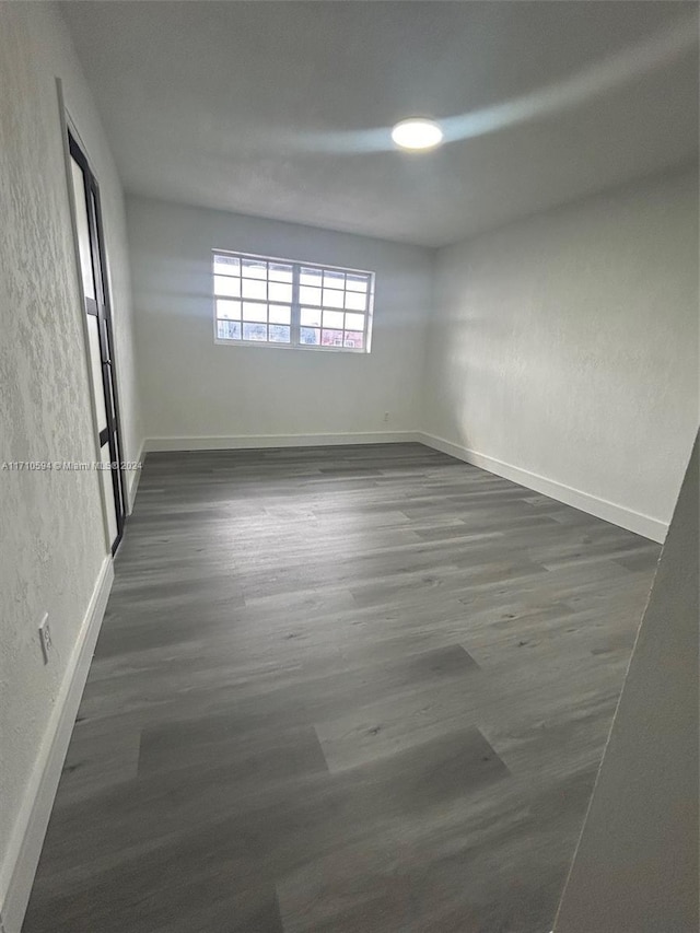 empty room with dark hardwood / wood-style flooring