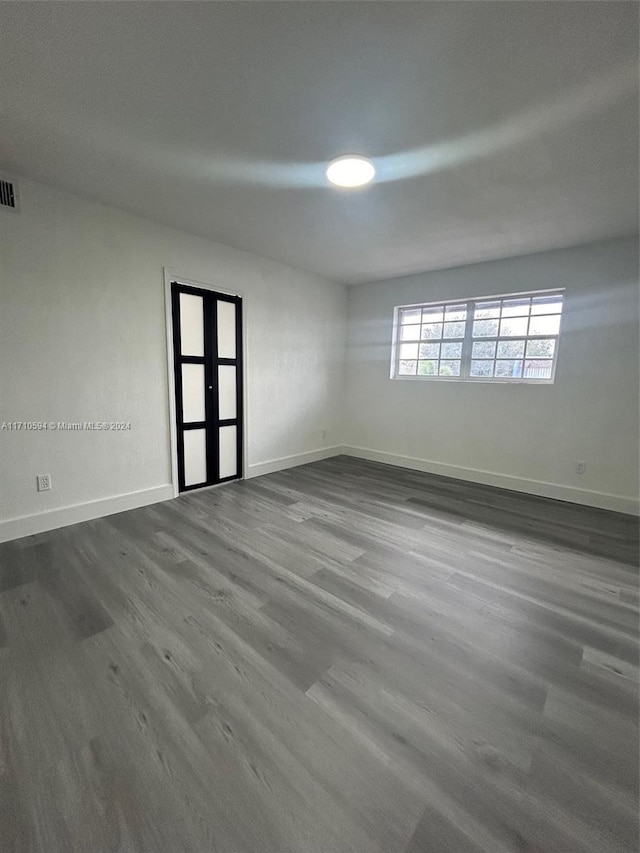 unfurnished room featuring french doors and dark hardwood / wood-style floors