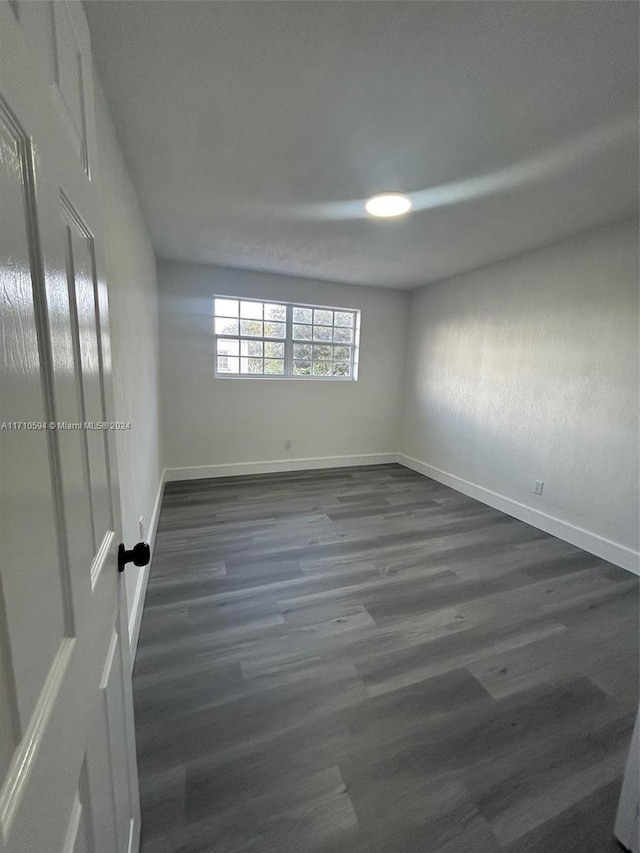 spare room featuring dark wood-type flooring