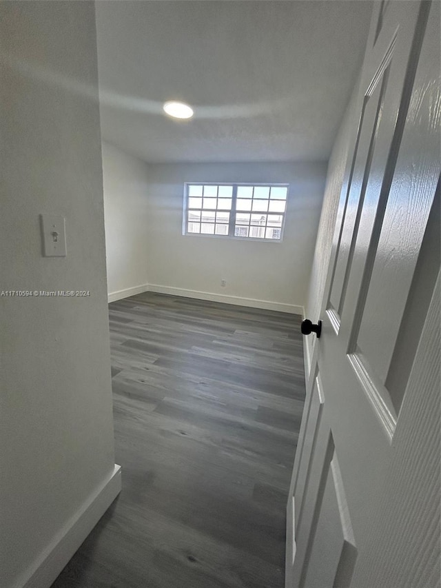 unfurnished room with dark hardwood / wood-style flooring