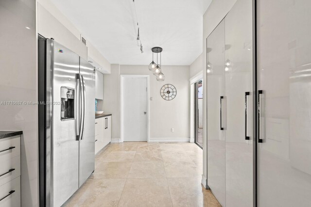 kitchen with pendant lighting, white cabinetry, stainless steel refrigerator with ice dispenser, and track lighting