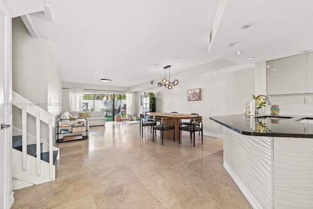 dining area with sink and a notable chandelier