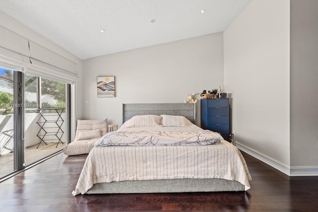 bedroom with dark hardwood / wood-style floors, a textured ceiling, access to outside, and vaulted ceiling