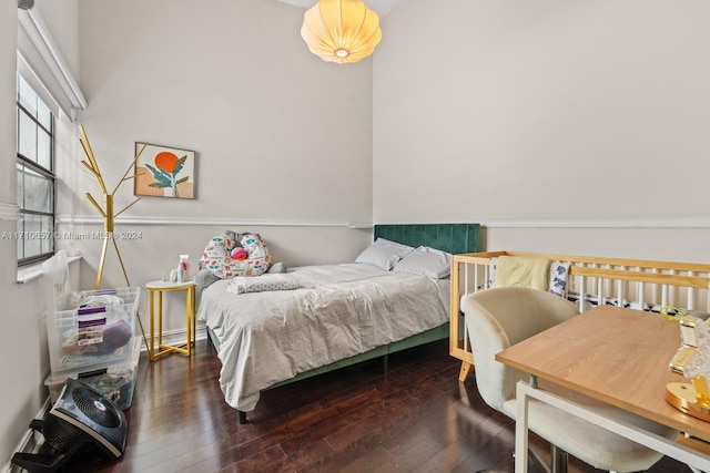 bedroom with dark hardwood / wood-style floors