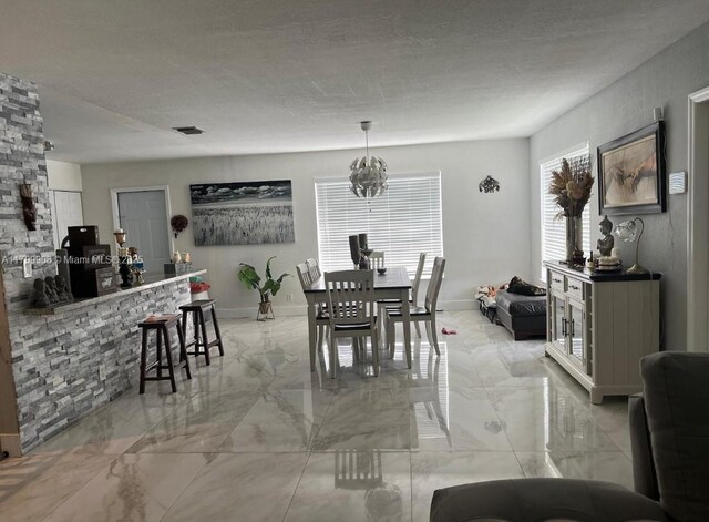 dining space featuring a textured ceiling and a notable chandelier