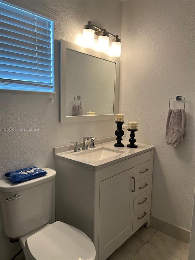 bathroom with tile patterned flooring, vanity, and toilet