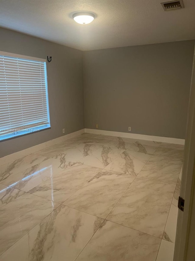 spare room with a textured ceiling