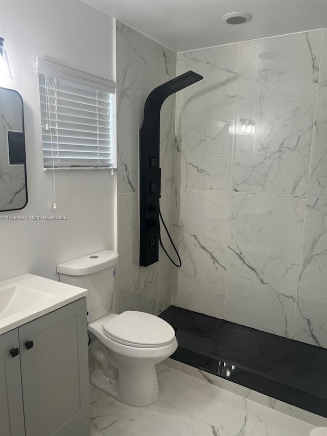 bathroom featuring vanity, toilet, and tiled shower