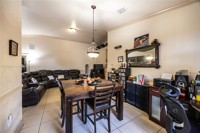 dining room with light tile patterned floors, lofted ceiling, and ornamental molding